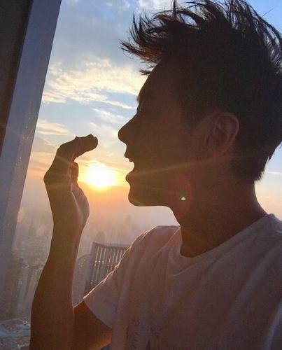 林志颖在微博晒出一张站在夕阳下的照片,身穿白色半袖的他,侧面